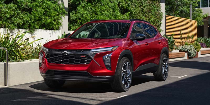 A red chevy Trax park outside the building
