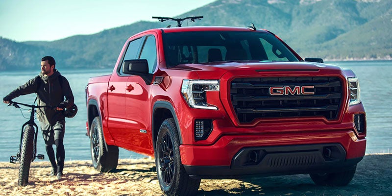 A red 2019 GMC Sierra parked on a sandy beach