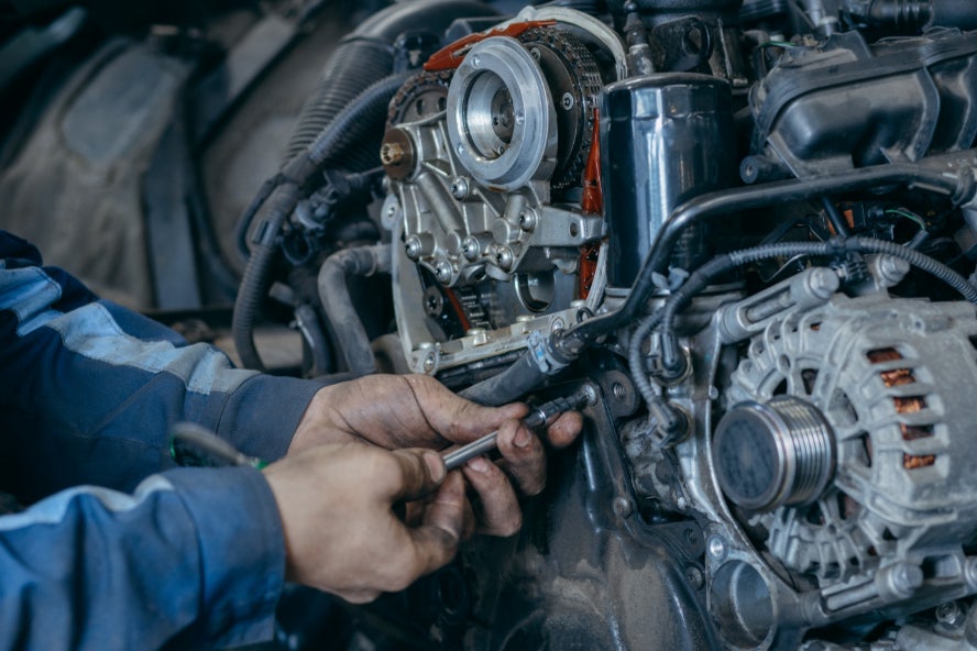A technician repairing a vehicle's engine.
