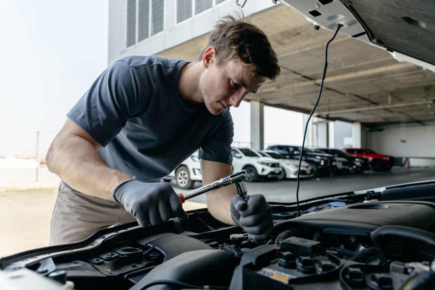 A mechanic working on a vehicle's engine.