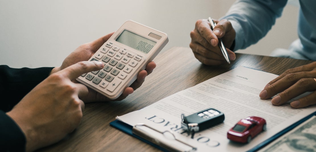 Two people going over a vehicle's financing contract.